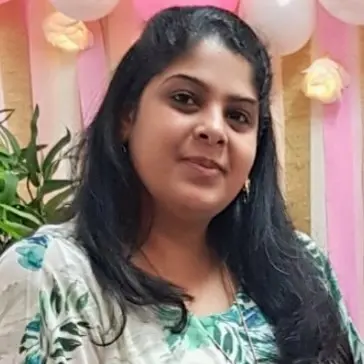 Portrait of Manasa Mahalingam, Mentor(SHE:) Operations Lead, smiling in a festive setting with balloons in the background.